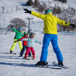 Instructor teaching kids skiing